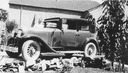 Image of Andrew P. Hill, Jr. standing next to a car in front of the house